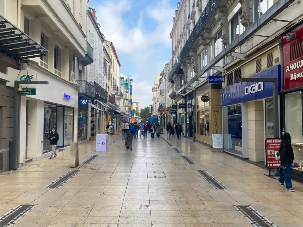 Rue commerçante animée à Vichy avec boutiques et passants